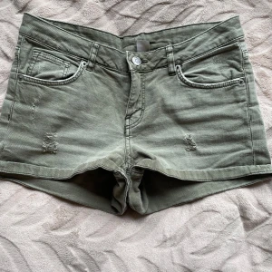 Gröna shorts med slitningar - Snygga gröna shorts med slitningar fram. Trendiga och perfekta till sommaren.
