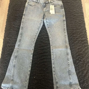 Ljusa Lågmidjade bootcut jeans från Gina Tricot - Snygga ljusblå Lågmidjade bootcut jeans från Gina Tricot, dom är i storlek 36. Köpta för 499kr, dom är i nyskick så endast testade. 