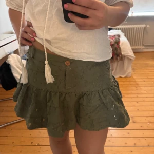 Grön volangkjol - Söt grön kort kjol med volanger och lite glitter i, den har lite sliten stil. 