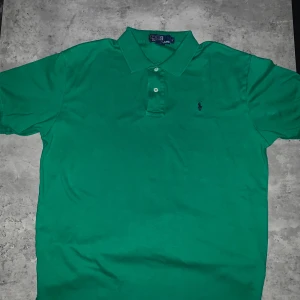 Grön pikétröja från Ralph Lauren - Säljer en snygg grön pikétröja från Ralph Lauren. Försöker rensa garderoben, den har en väldigt sommar vibe med den gröna färgen som ger ifrån sig sommar känslan. 100% Cotton som gör att den är ganska töjbar! Vid fler och tydligare bilder, skiv🥰