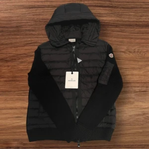 Moncler Cardigan Storlek XL (Passar Bättre Som Large) - Jag säljer en helt ny Moncler-cardigan i storlek XL. Den passar bättre för någon som vanligtvis bär storlek Large då den är lite mindre i passformen. Jackan är i perfekt skick och har aldrig använts, fortfarande med alla taggar kvar. 