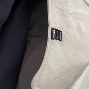 Beige omlottopp från SHEIN - Säljer en stilren beige omlottopp från SHEIN med långa ärmar och knytning framtill. Perfekt för en avslappnad och chic look. Passar bra till både jeans och kjol. 🌟