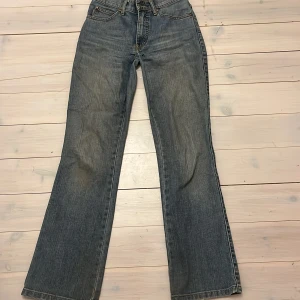 Blå jeans från Flash - Säljer ett par mid/low waist jeans från Flash. De har en bootcut-stil och fina detaljer, de har ett litet hål men kan sys igen lätt! 