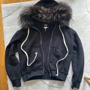 Svart hoodie med pälsdetalj från Witness - Hej, säljer denna päls hoodien som är i good skick som ny, använd få gånger bara ✅.                                Storlek: S 📏                                                                 För mer information/bilder fråga i privat chatt 💬 Utskickning från 1-2 Dagar efter köp 🚚💨