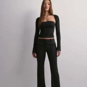 Svarta linnebyxor  - Eleganta svarta linnebyxor med låg midja och bootcut-stil. Perfekta för en stilren look. Byxorna har en klassisk design som passar till många olika tillfällen. Aldrig använda. Slutsålda i storlek 40 på Nelly! 