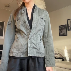 Vårjacka  - Säljer en grön jacka med knappar och flera fickor som jag köpte begagnat men aldrig använt. En knapp har ramlat av och det är en mindre fläck på insidan som säkert går att få bort, men det är inget man tänker på!! Hör av er vid frågor!! 🌸💞