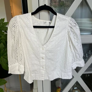 Vit broderad blus med puffärm - Superfin vit blus med broderade detaljer och v-ringning. Blusen har puffiga trekvartsärmar, knappar framtill och är gjord i bomull storlek 36💓💓