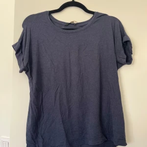 Mörkblå t-shirt  - Enkel mörkblå t-shirt med rund hals och upprullade korta ärmar. Modellen är loose fit.