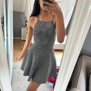 Svartvit kortklänning från H&M  - Supersöt svartvit kortklänning från H&M med smala axelband och rutigt mönster. Endast testad!