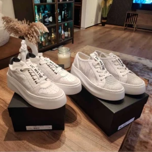 Vita sneakers från Vic Matié med platåsula - Två par trendiga vita sneakers från Vic Matié med kraftig platåsula. Ena paret har perforerat meshmaterial och det andra är i skinn med svarta detaljer vid hälen. Båda har snörning och märkets logga på plösen. Perfekta för dig som vill sticka ut. Ny pris 3000 per styck.