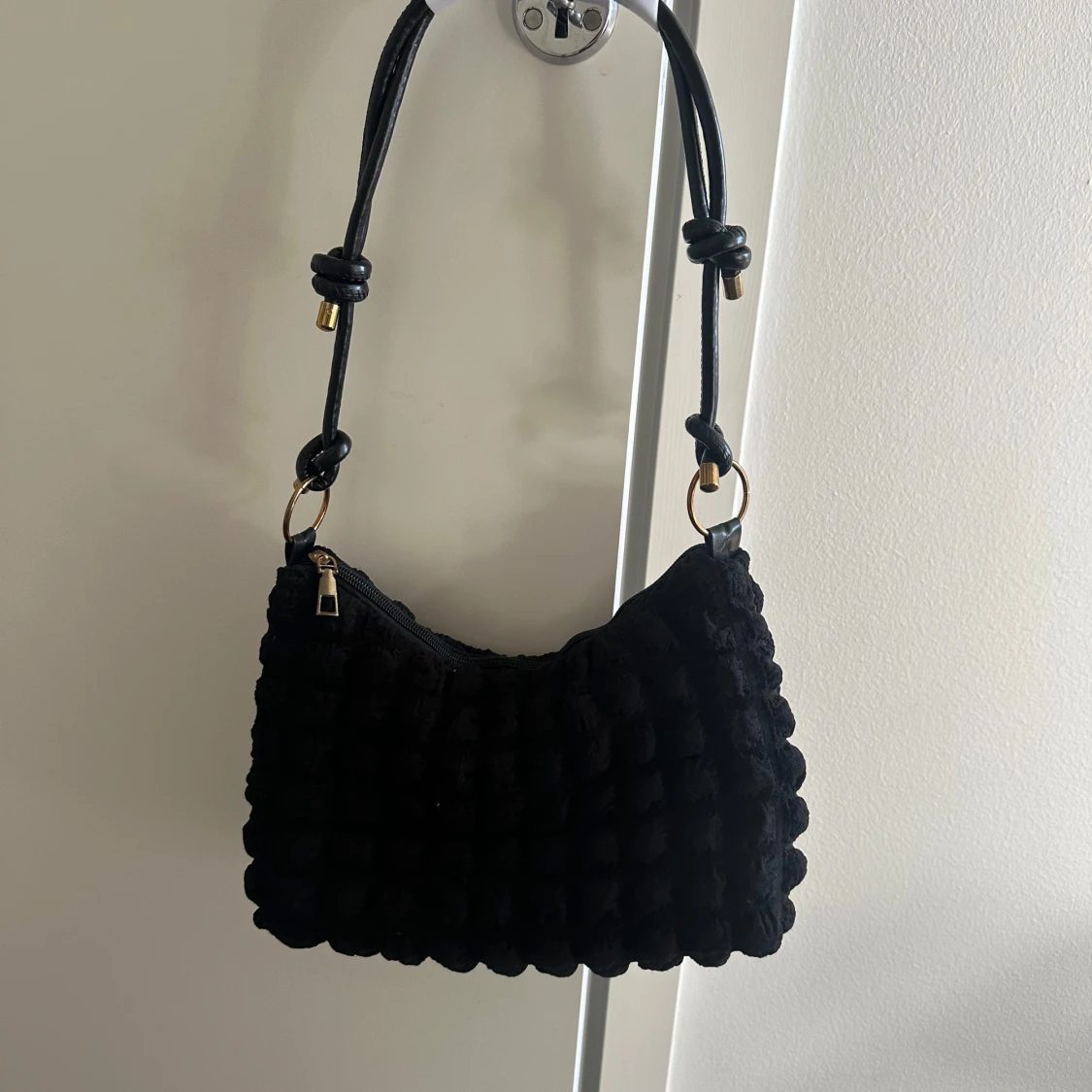 Svart quiltad axelväska med knutdetaljer