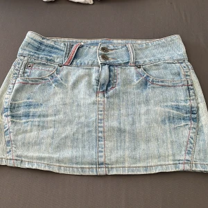 Ljusblå jeanskjol från Seriously Sally - Snygg ljusblå jeanskjol från Seriously Sally klassiska fem fickor. Kjolen har dubbla knappar framtill och cool tvättad denimlook. Original pris:250kr säljer för: 100kr