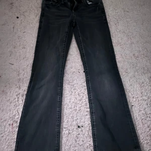 Mörkgrå bootcut jeans - Snygga mörkgrå jeans med bootcut passform och klassiska fickor både fram och bak. Storleken är 158. Jeansen har en lätt tvättad look och raka ben som blir vidare nertill. Perfekta för en avslappnad och trendig stil.