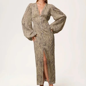 Zebramönstrad långklänning med slits - Vill kika på intresset för min otroliga adoore klänning i detta fina zebra mönster. Endast använd 1 gång så som ny, storlek 36! 