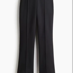 Svarta kostymbyxor med bootcut - Säljer ett par svarta kostymbyxor med bootcut-snitt. Byxorna har pressveck och sitter snyggt i midjan. Perfekta för en clean och stilren look. Materialet känns mjukt och följsamt, troligtvis polyesterblandning. Lågmidjade, är 174 och dom passar perfekt i längden. Luftig material! 