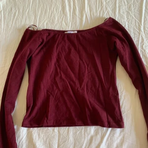 Vinröd offshoulder topp Subdued XS - Snygg vinröd offshoulder topp från Subdued i storlek XS. Toppen har långa ärmar och är tillverkad i mjuk bomull, perfekt för en stilren och trendig look. Enkel att matcha med både jeans och kjol.