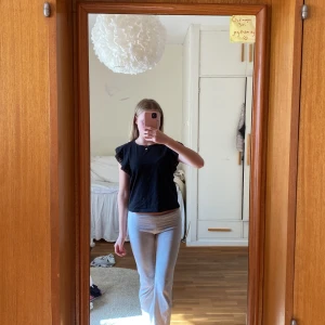 Svart volangtopp - Säljer en svart volandtopp med broderade ärmar från H&M i storlek XS. Den är i nytt skick. Enkel att styla och bekväm att bära 💞