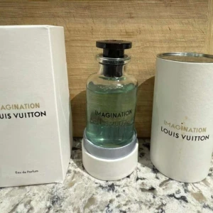 Louis Vuitton Imagination parfym - Lyxig parfym från Louis Vuitton, Imagination Eau de Parfum. Flaskan är genomskinlig med ljusblå vätska och svart lock. Kommer med original vit kartong och rund förvaringsask med guldfärgad text. Perfekt för dig som gillar exklusiva dofter.