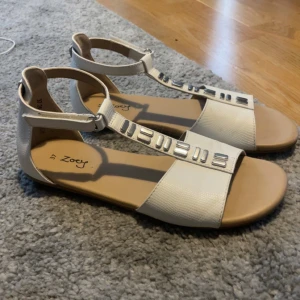 Vita sandaler - Vita sandaler som har justerbart ankelband. Perfekta för varma dagar och ger en fräsch look till din outfit!! Använd väldigt fåtal gånger ej skadade nån stans.