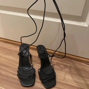 Svarta klackar med snörning - Så snygga sommarklackar med snörning som man knyter. Perfekt i sommar, i storlek 39. Totalt 10 cm hög