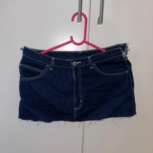 Mörkblå jeanskjol - Snygg mörkblå jeanskjol med rå, fransig kant nertill och slitna detaljer i midjan. Knappt använd av mig men köpt second hand. Så söt och inga fel med den förutom det jacket i midjan. 🌸