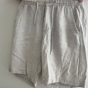 Beige linneshorts med snörning - Snygga beige shorts i linne med avslappnad passform och elastisk midja. Fint skick från Zara