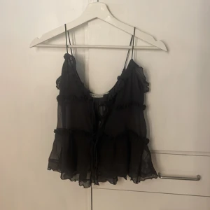 Volang topp - Supersöt svart linnetopp från Zara med tunna axelband och volangdetaljer. Jätte bra skick. Passar perfekt nu till sommaren.