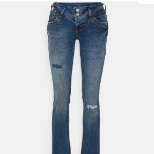 Blå bootcut jeans från LTB - Snygga blå bootcut jeans från LTB med slitna detaljer på benen och dubbla knappar i midjan. Jeansen har klassiska fickor med kontrastsömmar och är tillverkade i mjukt denimtyg. Perfekta för dig som gillar en avslappnad men trendig look.