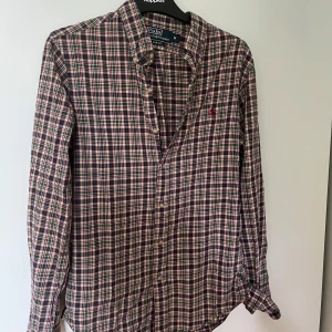 Rutig skjorta Polo Ralph Lauren M - Obs!! Om ni ska köpa köp via PostNord annars avbryter jag köpet. Riktigt snygg rutig skjorta från Polo Ralph Lauren i slim fit. Skjortan har klassiskt rutmönster i grönt, rött, blått, gult och vitt samt den ikoniska broderade loggan på bröstet. Långärmad med knappar hela vägen och mjukt bomullstyg. 
