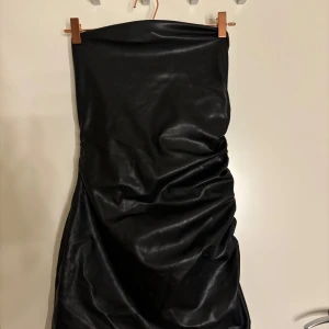 Svart klänning  - Säljer en svart klänning i skinn med scrunch på ena sidan, ASSNYGG💕💕💕💕