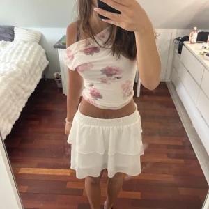 Vit volangkjol med resårmidja - Superfin vit kortkjol med dubbla volanger. man kan vika ner midjan så kjolen blir kortare, vilket jag brukar göra. 