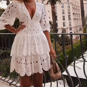 Vit broderad kortklänning med volang från Maje - !!!INTRESSEKOLL!!! Klänningen är från Maje, storlek 36! Superfin vit kortklänning med broderade detaljer och v-ringning. Klänningen har trekvartsärmar med puff, omlottkänsla och flera lager volang i kjolen. Perfekt för sommarens alla tillfällen och ger en romantisk vibe.