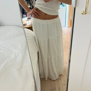 Vit maxikjol - Finaste långkjolen med volanger och resår i midjan. Lite nopprig men såå fin & skön, mycket stretchig så man kan ha low waist, passar då XS-M