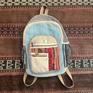 Färgglad Himalayan ryggsäck i hampa - Säljer en unik ryggsäck från Himalayan, tillverkad i hampa och bomull. Väskan har flera fack med dragkedja, mönstrade detaljer i rött, svart, beige och blått samt etniska inslag. Perfekt för dig som gillar boho-stil och vill sticka ut med färg och mönster.