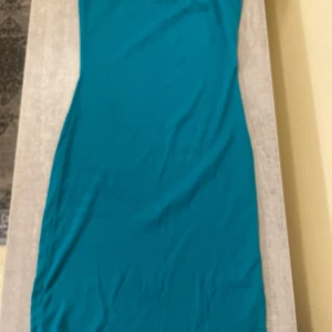 Turkos ribbad klänning Gina Tricot - Säljer en turkos, ribbad och tight klänning från Gina Tricot i storlek M. Klänningen är ärmlös och har en enkel, rak design som sitter snyggt på kroppen. Perfekt för dig som gillar färg och vill sticka ut lite extra.