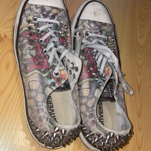 Mönstrade Converse All Star med nitar - Säljer Unika Converse All Star sneakers med ett färgglatt mönster och coola nitar över hela skorna eftersom dom tyvärr är för stora för mig. De har klassisk snörning och en vit tåhätta. 