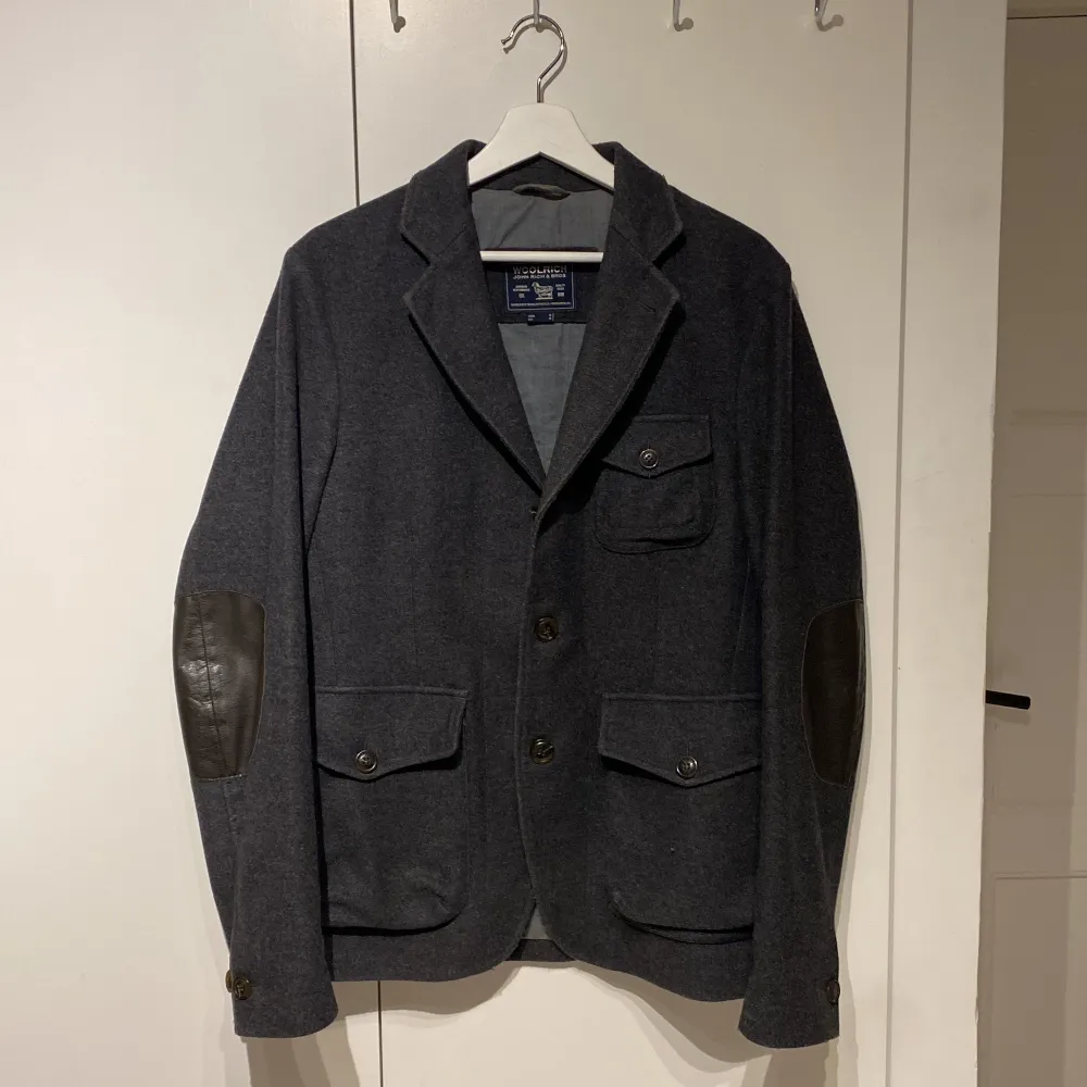Säljer denna väldigt snygga jacka/kortare rock/kavaj från Woolrich! Storleken som står är medium och den passar medium men kanske även en större small. Den är i riktigt bra skick och jag hittade inga defekter! Den är i ull, fodrad med polyester/bomull och armbågslapparna är i äkta läder. Woolrich har också väldigt högkvalitativa plagg så förvänta dig en lång livslängd om du köper. Helt perfekt nu till våren för dig som vill höja din stil. Skriv om du har frågor eller prisförslag! . Takit.