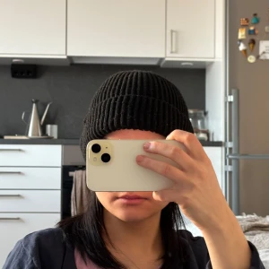 Svart ribbad mössa - Snygg svart ribbad mössa som passar perfekt för kyligare dagar. Den har en enkel och stilren design som gör den lätt att matcha med olika outfits.