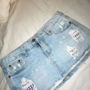 Ljusblå jeanskjol från T.ank jean - Säljer en cool ljusblå jeanskjol med slitna detaljer och lappade hål. Kjolen har en klassisk femficksdesign och knappgylf. Perfekt i sommar och den har även inbyggda små shorts💖midjemåttet är 39 cm rakt över!