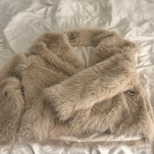 Beige pälsjacka - En fluffig beige pälsjacka. Den har en oversized passform och långa ärmar. Storlek S. Den har några fläckar längst ner inne i jackan men inget man ser💗
