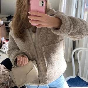 Beige teddyjacka - Säljer denna superfina och trendiga teddyjackan som tuver är lite för liten för mig. Den är i fint skick och har detaljer på kragen som syns på sista bilden. Den är i fint skick och är lite större i storleken😊