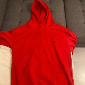 Röd hoodie från Ralph Lauren - Säljer en snygg röd hoodie från Ralph Lauren med klassisk logga på bröstet. Perfekt för en avslappnad stil med sin bekväma passform och huva. Ett måste för garderoben! 🔥