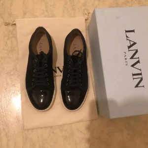 Lanvin - Snygga svarta sneakers från Lanvin med glans. De är tvärfeta o i fint skick. Säljer för endast 1699kr. Vid snabb affär är priset diskuter-bart. Hör av er vid frågor! Skriv för fler bilder:)