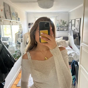 Beige offshoulder tröja - Säljer en stilren beige offshoulder tröja med lång ärm. Tröjan har en mjuk och bekväm passform. Använd ett fåtal gånger så i bra skick 