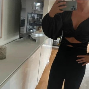 Svart satinblus - Snygg svart blus i satin med långa puffiga ärmar. Perfekt för en stilren look. Använd en gång