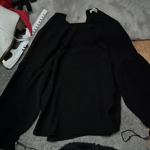 Svart långärmad topp från Carin Wester - Säljer en stilren svart långärmad topp från Carin Wester. Toppen har en elegant design med en hög hals och är perfekt för en chic look. Passar bra till både jeans och kjol. Perfekt för höst och vinter!