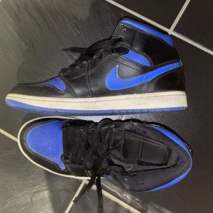 Jordan 1 - ÄKTA!!! Säljer mina Jordan 1 mid Royal Blue. Köptes 2020 på Sneak.se. Fint skick men täcken på användning på yttersulorna som visas på bilden. Priset kan diskuteras! 💙