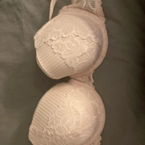 Spets-bh - Säljer en elegant vit bh med spetsdetaljer. Den har en mjuk och bekväm passform med vackra spetsmönster över kuporna. Perfekt för att känna sig både bekväm och stilfull. 💖