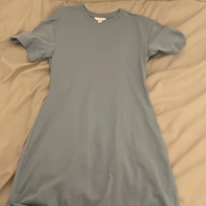 Ljusblå klänning från H&M - Säljer en enkel och stilren ljusblå klänning från H&M. Klänningen har korta ärmar och en rund halsringning, perfekt för en avslappnad look. Säljer en vit exakt likadan💘