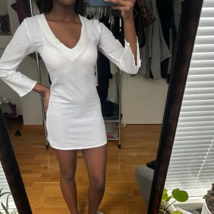 Vit student  klänning med v-ringning - vit klänning med v-ringad hals. Klänningen har en tight passform. Kan användas sol student klänning.